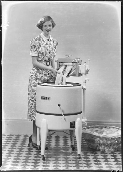 Woman using wringer washing machine